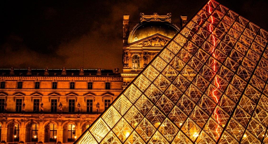 The Louvre museum and glass pyramid illuminated at night