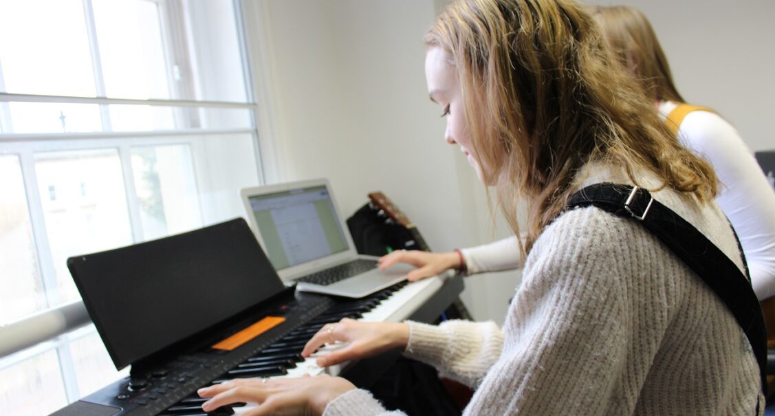 A Red Balloon student playing the keyboard